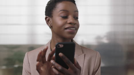 close-up-portrait-of-professional-african-american-business-woman-smiling-enjoying-texting-browsing-using-smartphone-in-office-workpace