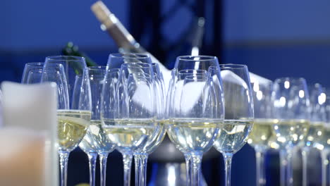 panning shot showing rows of catering service champagne glasses presented on event table setting