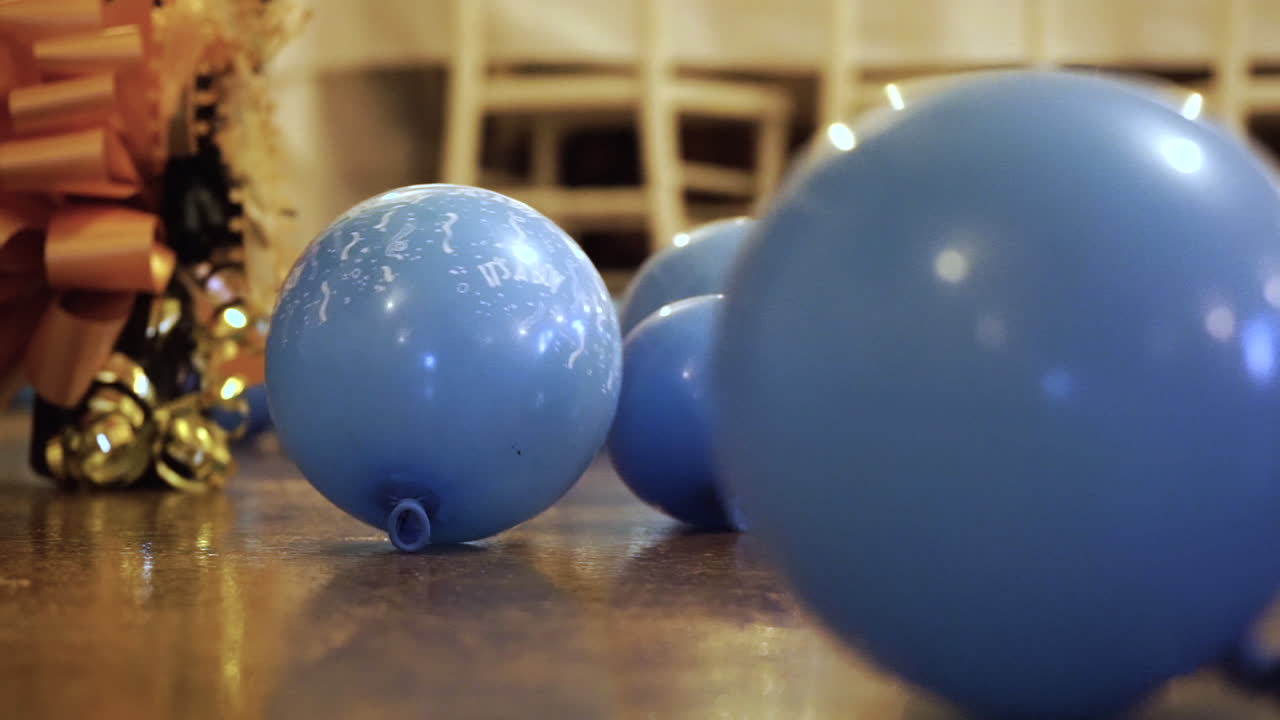 globos azules con 'es un niño' impreso en ellos rodando por el suelo, cerrar