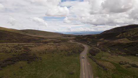 Car-driving-along-an-alpine-dirt-road