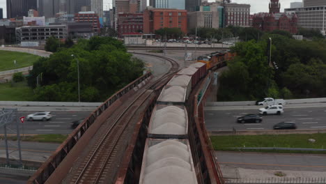 Hacia-Adelante-Revelan-El-Pie-Del-Tren-De-Carga-En-La-Vía-Que-Conduce-Al-Puente-Sobre-La-Carretera-Muy-Transitada.-Dallas,-Texas,-Nosotros