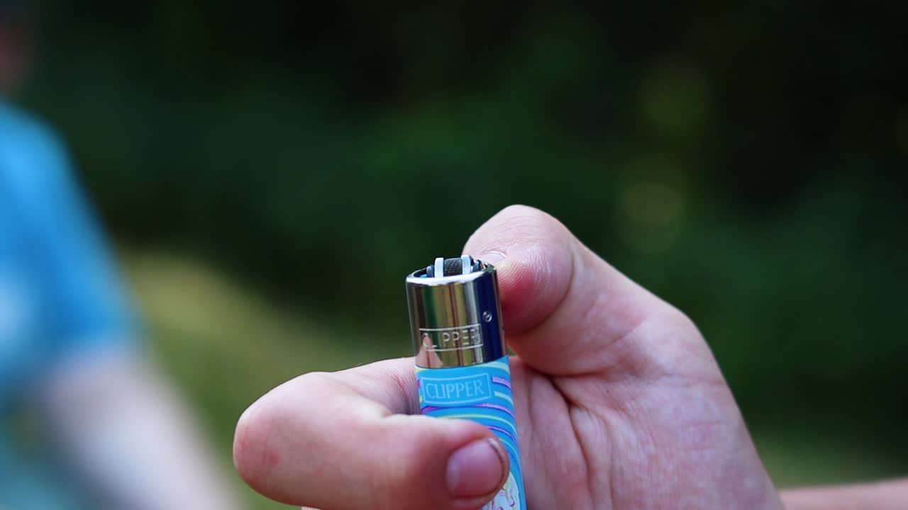 mano enciende un encendedor, cámara lenta, primer plano