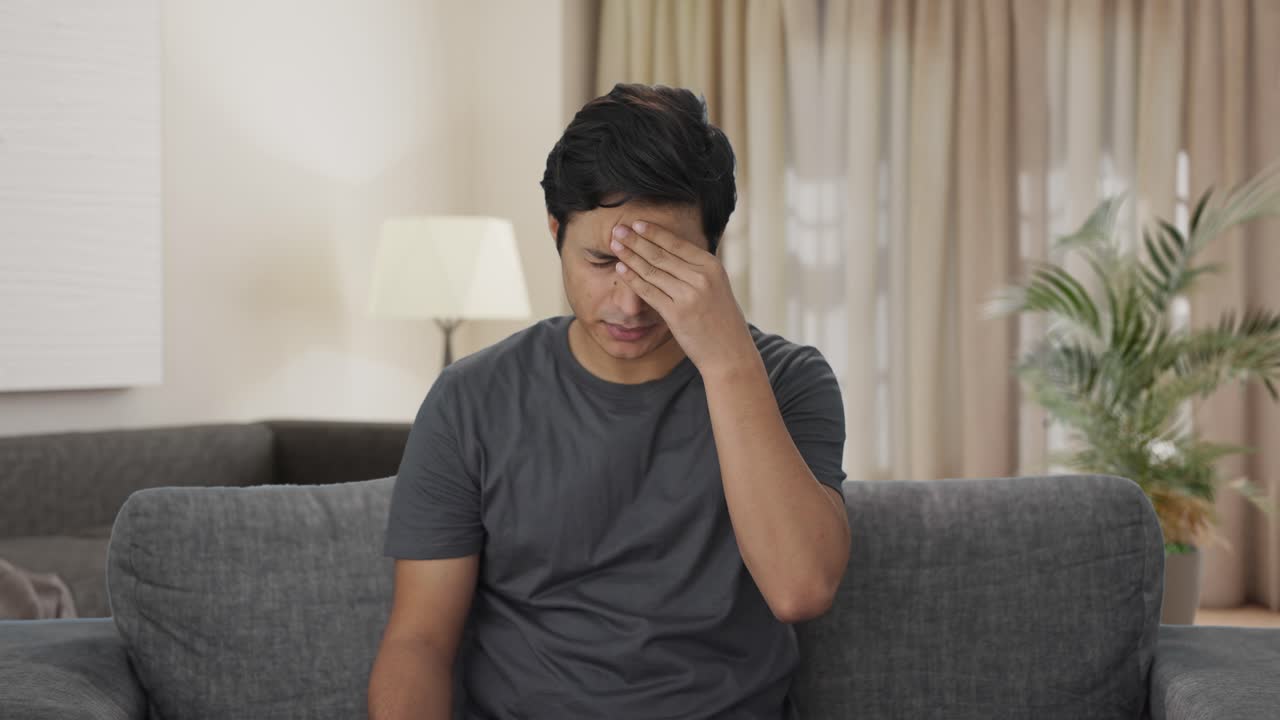 인도인 남자가 두통에 약을 먹고 있습니다.