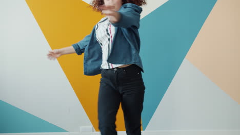 young woman dancing in front of colorful wall