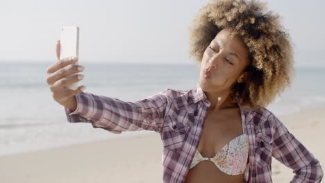 beach young girl taking selfie with smartphone.