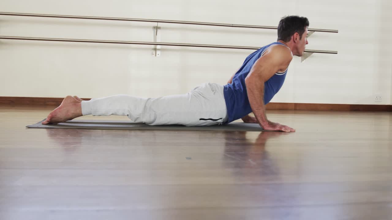 집중된 백인 남자가 체육관에서 요가를 연습하고, 느린 동작