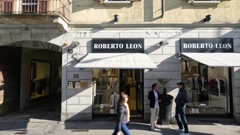 dos hombres conversando fuera de una tienda de ropa