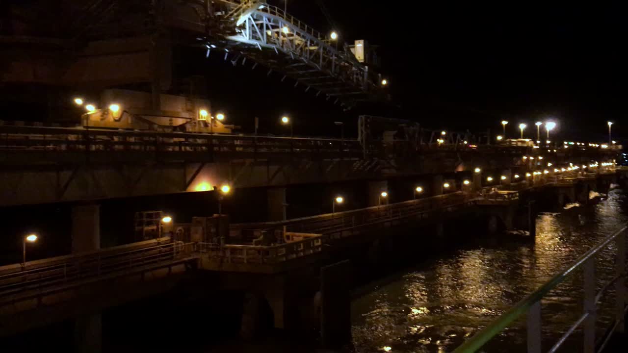 クレーンと船が停泊する夜の港湾の全景