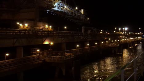 Establishing-shot-port-and-harbor-at-night-with-cranes-and-ships