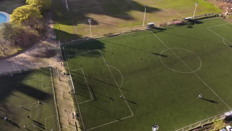 people practicing shots on soccer goal in football green court, grass field