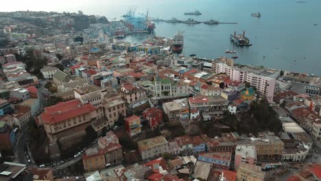 aerial orbit of cerro concepcion colorful houses and lutheran church, valparaiso city and sea port in the back, chile