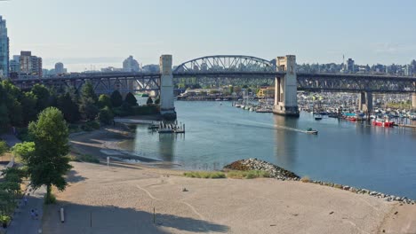 Hermosa-Toma-Aérea-De-Drones-En-El-Parque-De-La-Playa-De-La-Puesta-Del-Sol-Que-Se-Desplaza-Hacia-El-Puente-De-La-Calle-Burrard---Norte-De-Vancouver,-Columbia-Británica,-Canadá