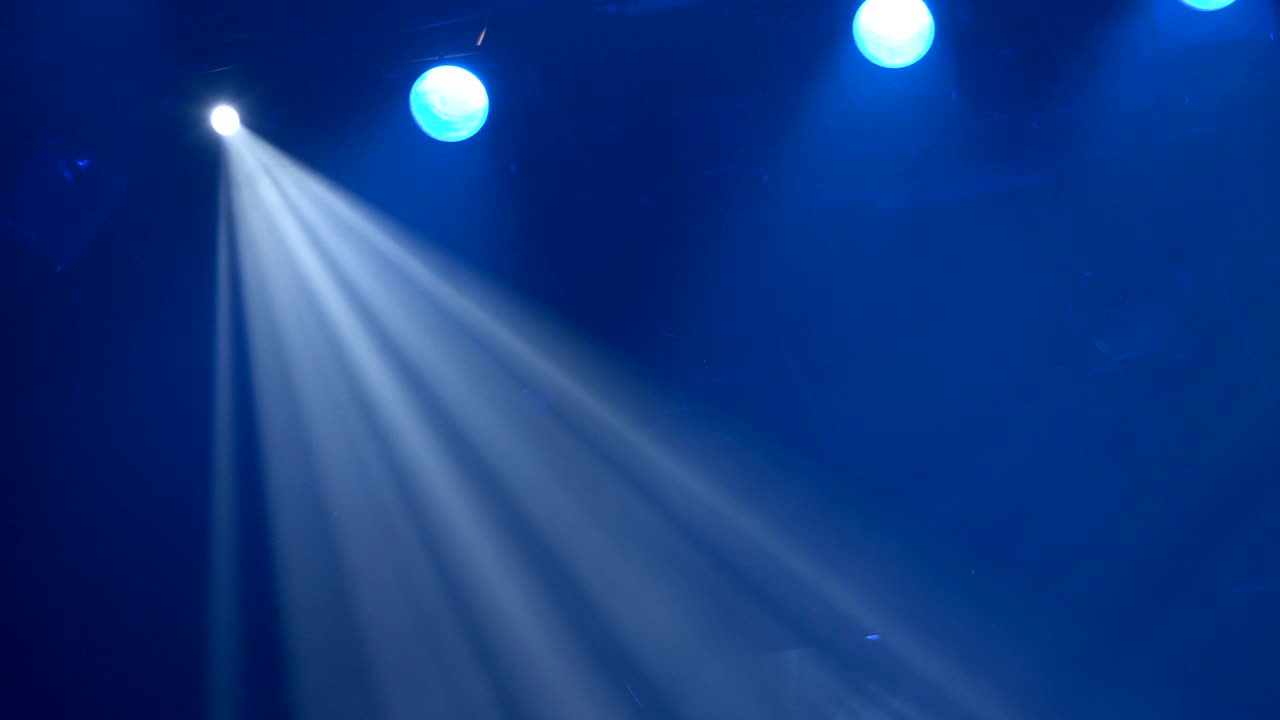 el foco a través del humo en el escenario. equipo de iluminación. luces de efecto. escáner. cambiadores de color. yugo móvil. cabeza móvil