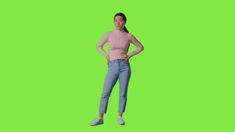 full length studio portrait of frustrated or angry woman standing against green screen