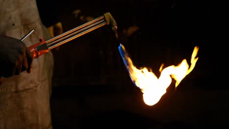 metalsmith holding welding torch in workshop 4k