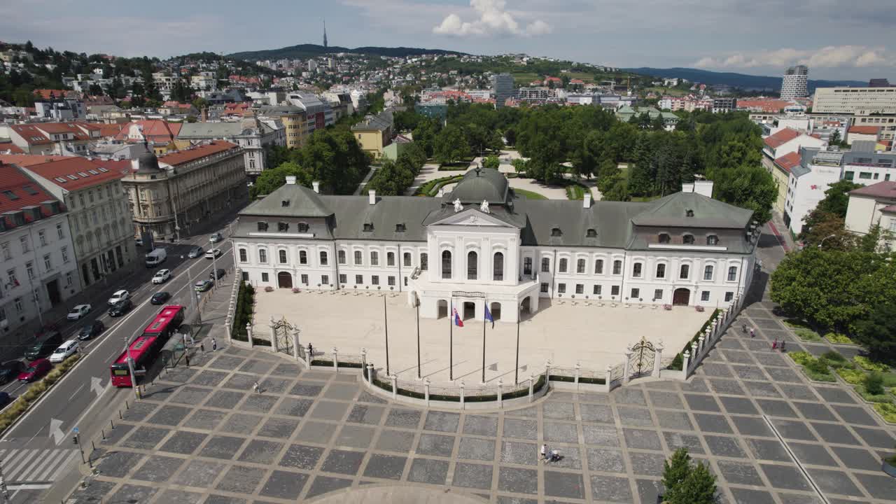 Aerial view capturing the Grassalkovich Palace, Bratislava's presidential residence, alongside Hodzovo namestie square and gardens. Circle Dolly