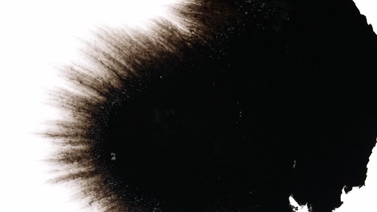 Gocce d'inchiostro nero su sfondo bianco