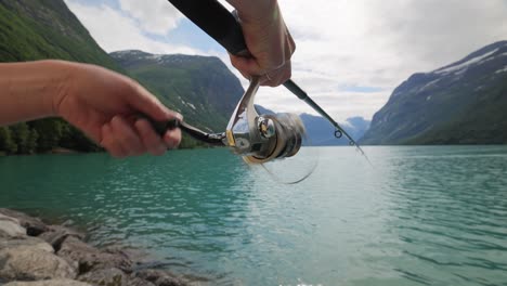 woman fishing on fishing rod spinning in norway.