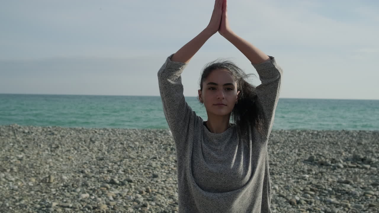 mujer practicando yoga en la playa