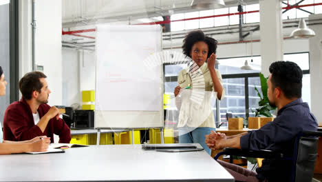 Animation-of-loading-circle-over-african-american-woman-making-presentation-to-business-colleagues