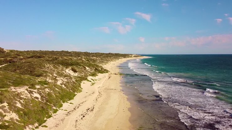 Eine ruhige Luftaufnahme einer australischen Küste mit klarem Himmel und sanften Wellen.