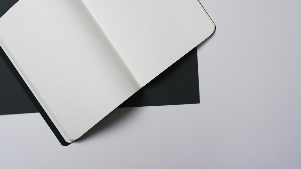 Video of book with white blank pages and copy space on black and white background
