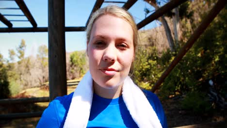 Tired-woman-wiping-sweat-after-workout-during-obstacle-course