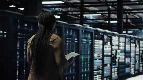 technician walking in data center, using app on tablet to ensure error free rigs