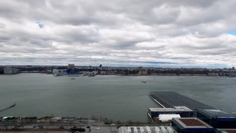 Aerial-over-Hudson-River-water-facing-New-Jersey-on-a-cloudy-day-in-Manhattan,-New-York