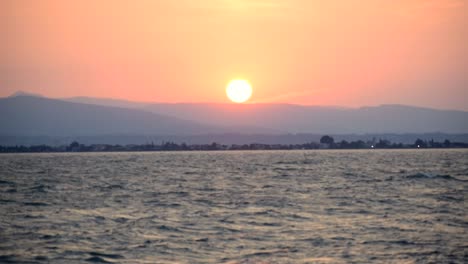 Ducks-flying-by-in-front-of-a-beautiful-dawn-in-Italy,-Garda-Lake