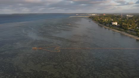 aerial flyover of arrow-shaped fishing structure on a shallow reef in tonga