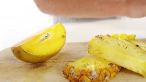 rebanadas y piña cortada por la mitad en tabla de cortar