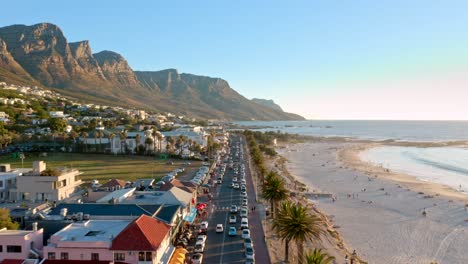 flying over the bustling main street of camps bay with a mountains in background