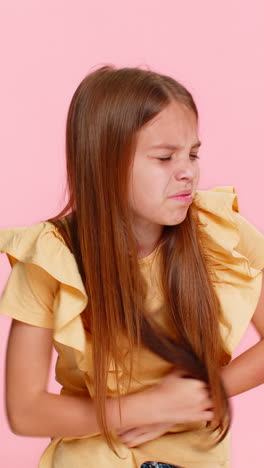 child girl kid holding stomach in pain with scared facial expression showing illness and discomfort