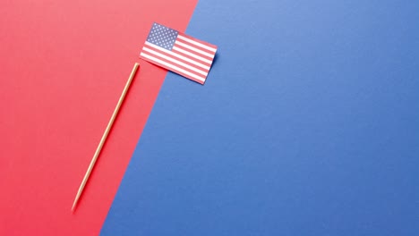 National-flag-of-usa-and-stick-lying-on-red-and-blue-background-with-copy-space