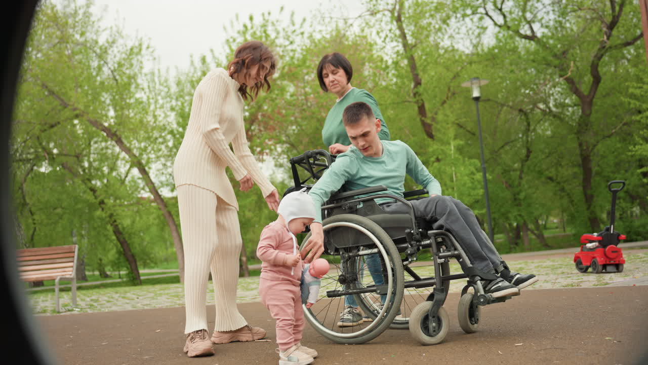 Family Gathers In Park, Child Explores Surroundings In Inclusive Park Setting With Family, Young Child Actively Engages In Park Area Close To Family Members Within Welcoming Environment