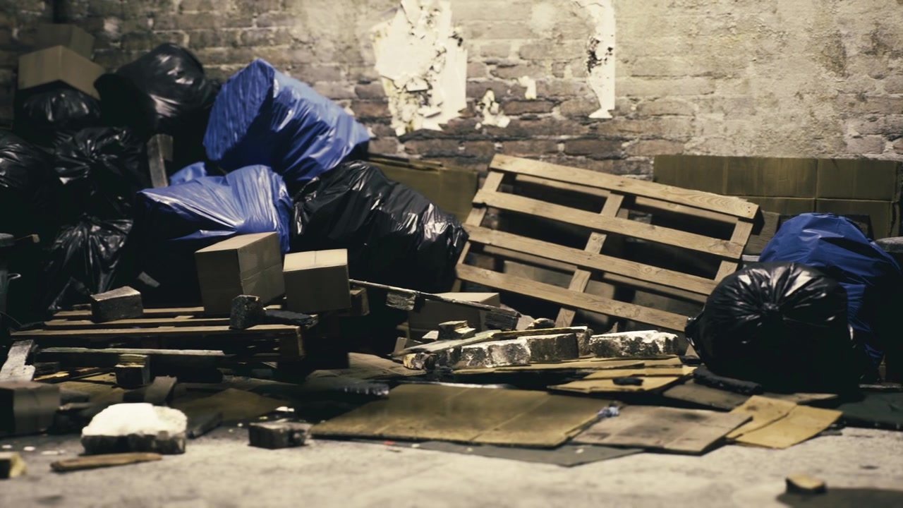 Messy corner of an abandoned warehouse filled with discarded items and debris