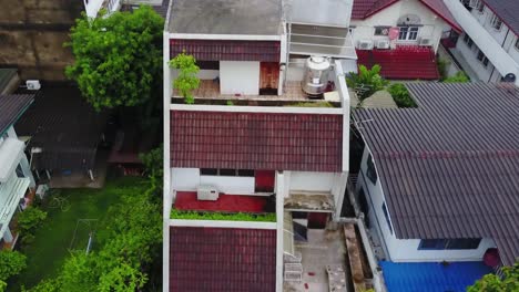 vista aérea de casas residenciales con techos de azulejos rojos y jardines