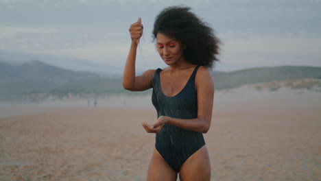 girl model walking beach pouring sand in hands summer twilight close up.