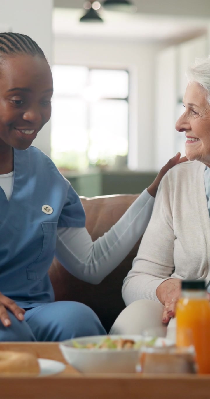 Friendly Nurse Caring for Elderly Woman at Home