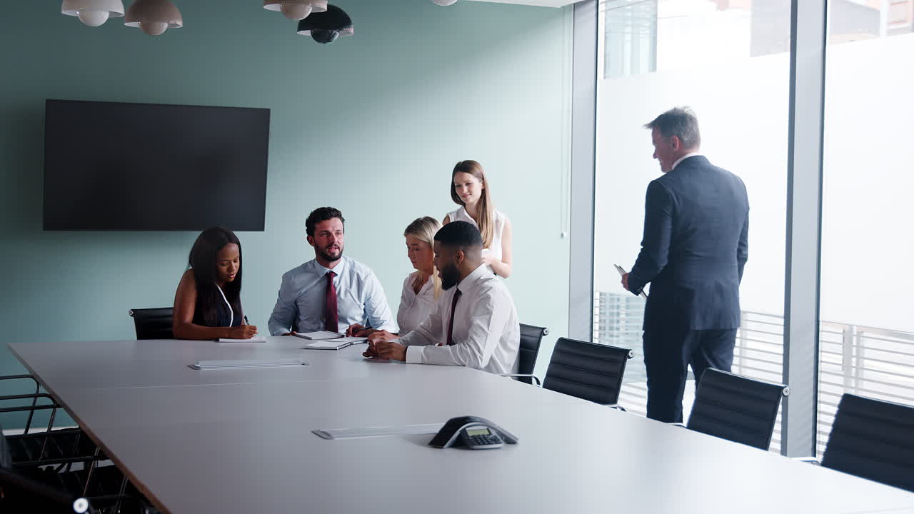 grupo que colabora en una tarea en el día de evaluación de la contratación de graduados mientras es observado por el equipo de contratación