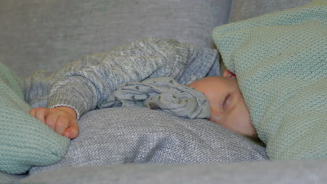 cute cosy two year old boy sleeping with clothes on, close up