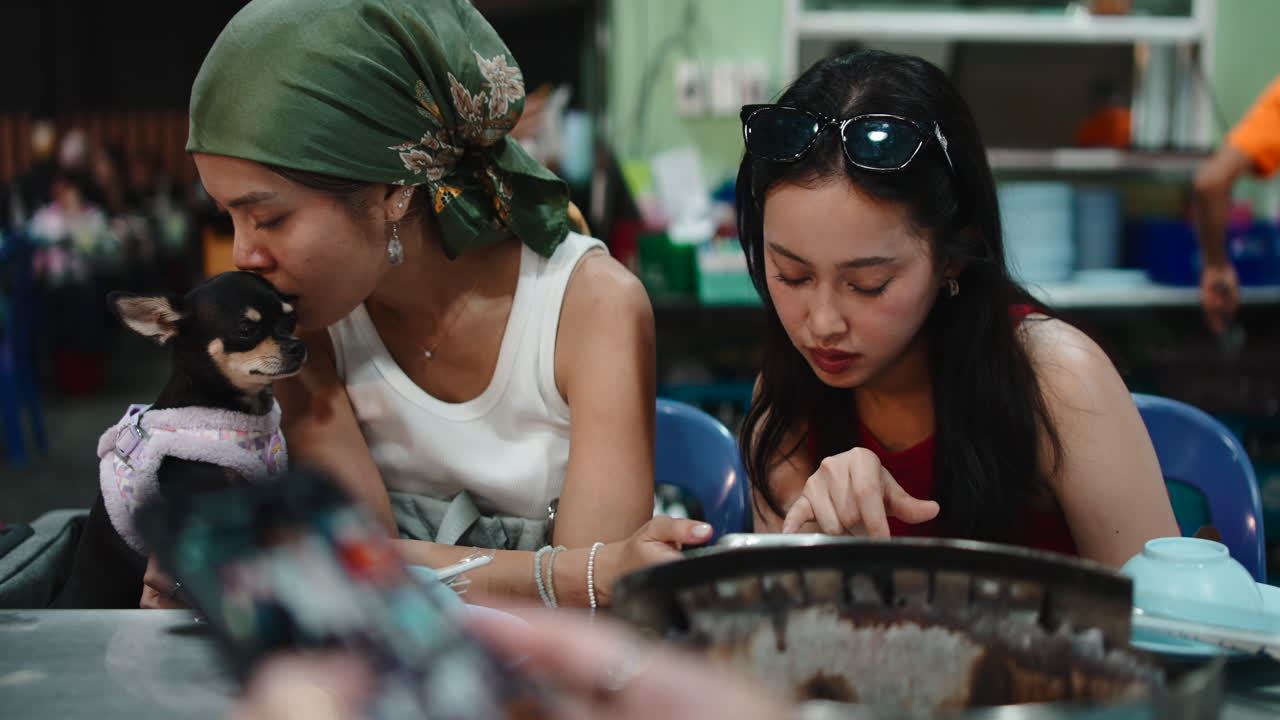Two women dining with a dog