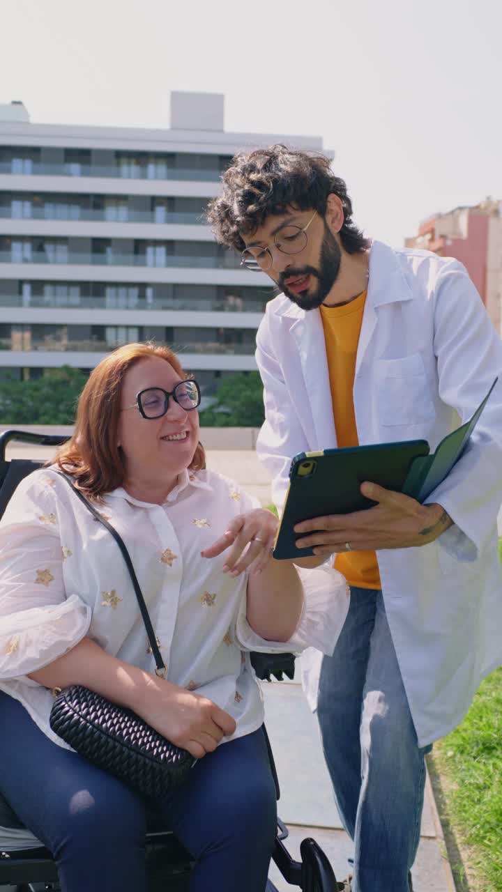 Doctor Consults with Patient in Wheelchair Outdoors