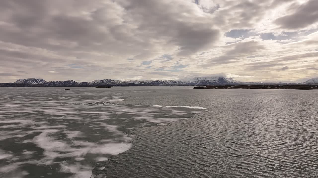 aerial icy lake Mývatn meets snow peaks and cloudy sky near Skútustaðir in Reykjahlíð Iceland