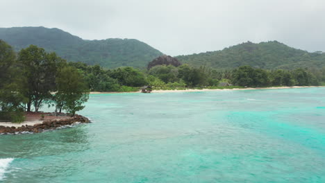 Volando-Bajo-Sobre-El-Mar-Caribe-Turquesa-Hacia-Una-Isla-Tropical-Desierta