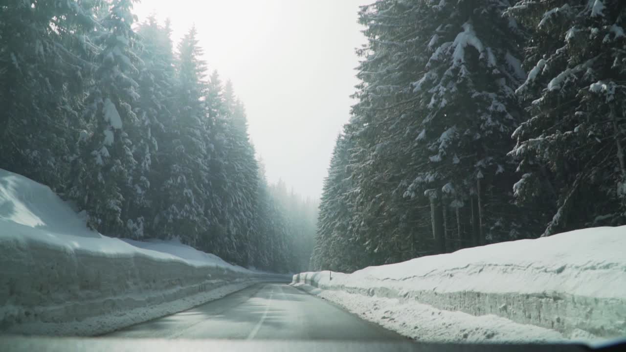 Driving in a car through a road covered with large amounts of snow