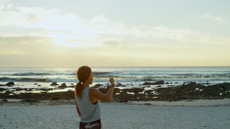 woman standing with hands on hip on beach 4k