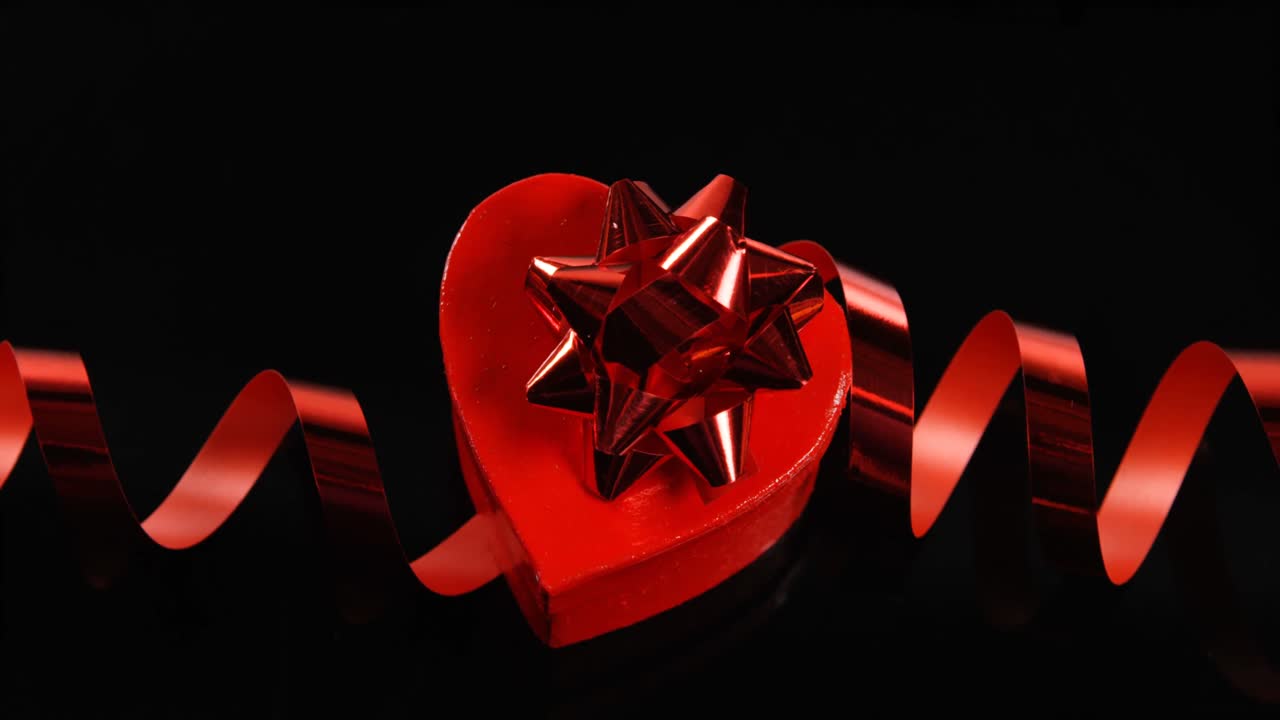 красное сердце и стример на черной поверхности 4k