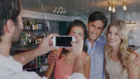 animación de procesamiento de datos sobre un camarero caucásico tomando una foto de un grupo de amigos en un bar.